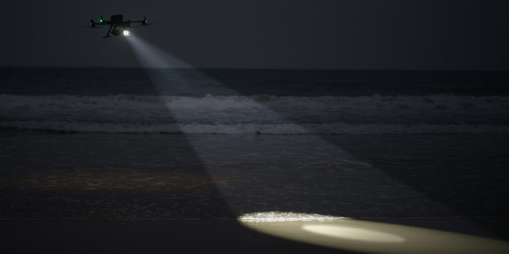 Zenmuse S1 spotlight beam lighting a night scene from the air